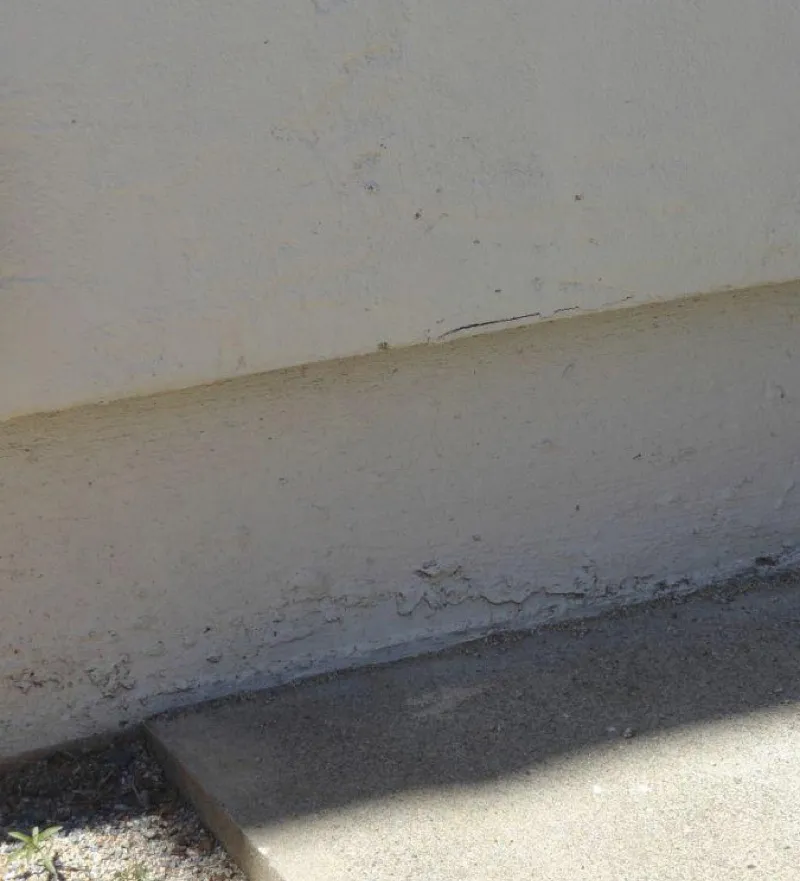 Noncombustible 6-inch base siding on stucco home with hardscape groundcover
