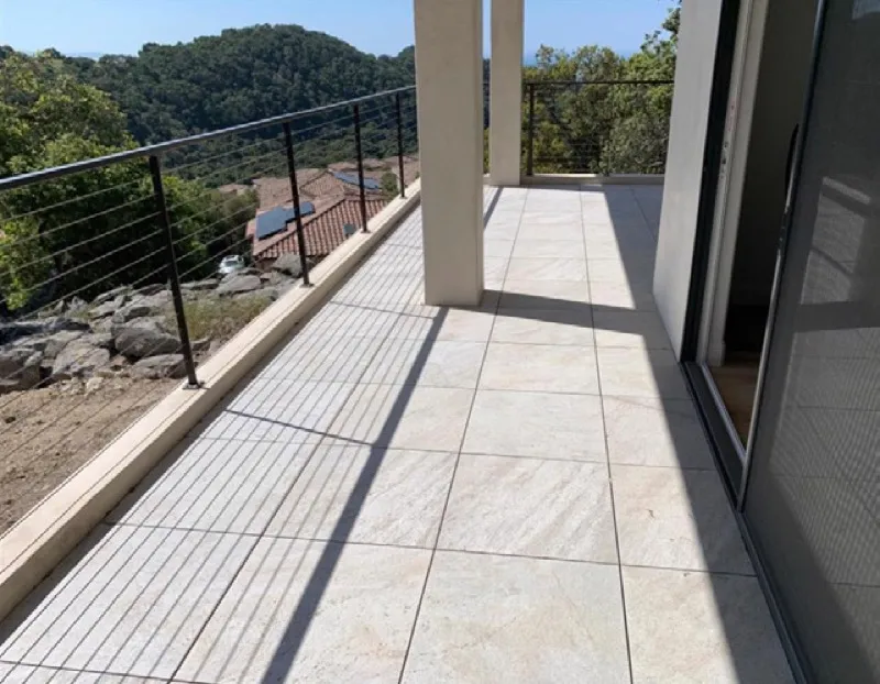 Noncombustible tile deck with metal cable railing on hillside home