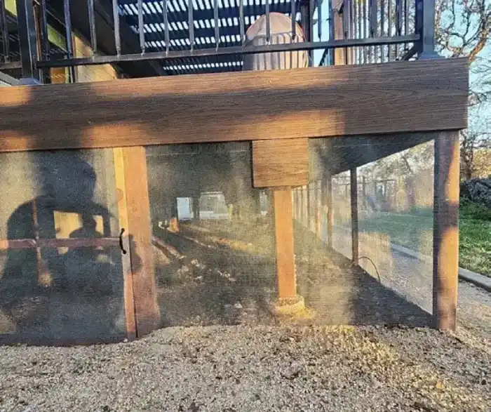 Under-deck area with mesh screening installed to prevent ember intrusion and debris accumulation